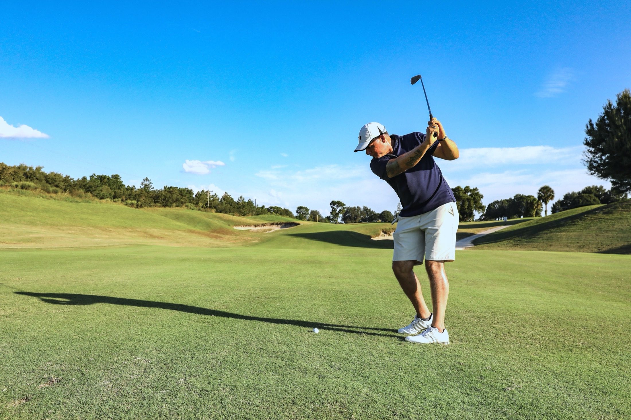 Golfer at the top of the backswing on an open fairway